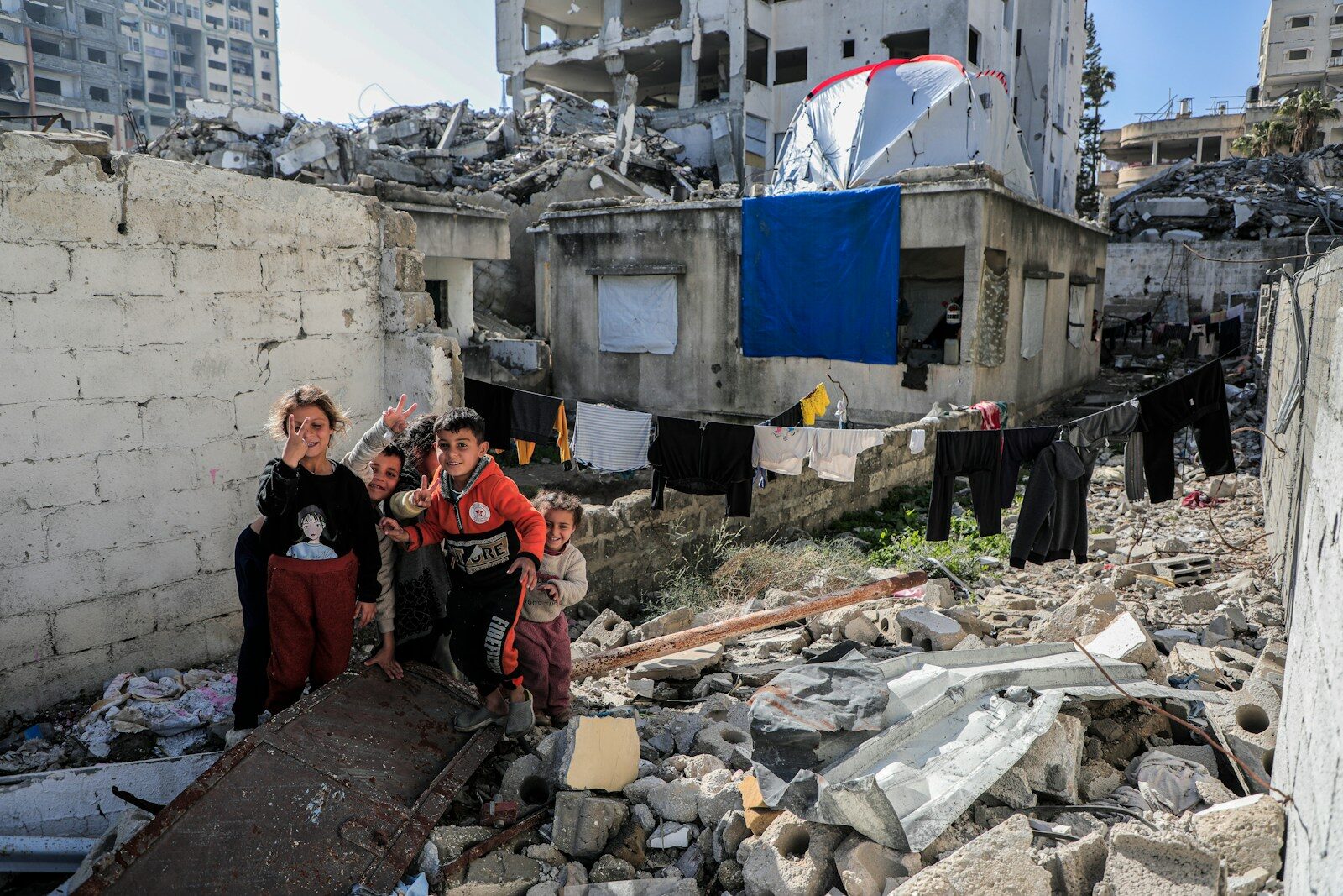 Foto: (c) Unsplash, Mohammed Ibrahim A group of people standing next to a pile of rubble