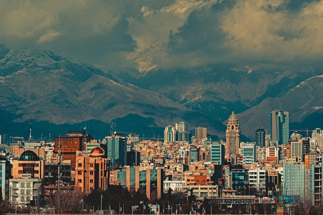 Irã: da Revolução de 1979 à primeira sucessão hereditária da liderança suprema Vista aérea de Teerã, capital do Irã, com sua paisagem urbana e montanhas ao fundo.